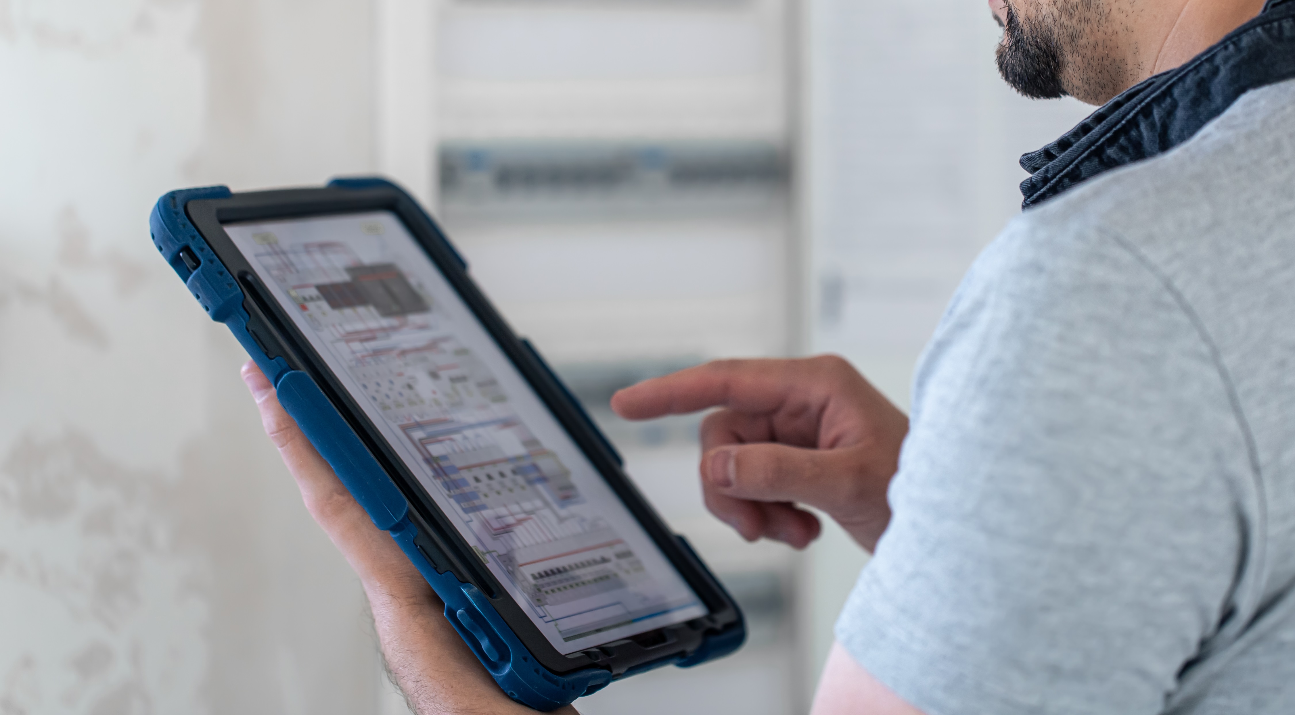 Electrical technician looking focused while working in a switchboard with fuses.